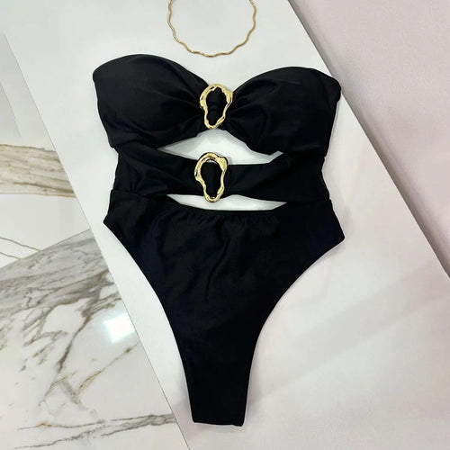 Black one piece with gold rings on a marble surface