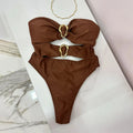 Brown bikini with gold rings on a white surface