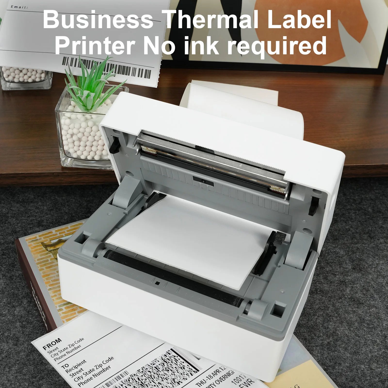 Business thermal label printer on a desk with labels and ink cartridges.